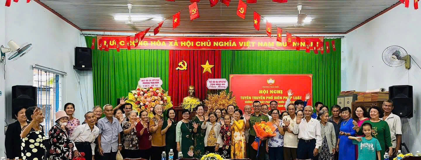 Báo cáo viên Đại úy Nguyễn Hữu Linh chụp hình lưu niệm cùng người dân tham dự chương trình